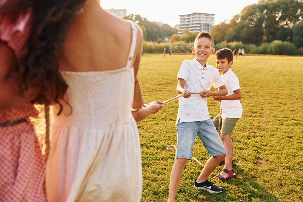 Having fun. Group of happy kids is outdoors on the sportive field at daytime. - Fotoğraf, Görsel