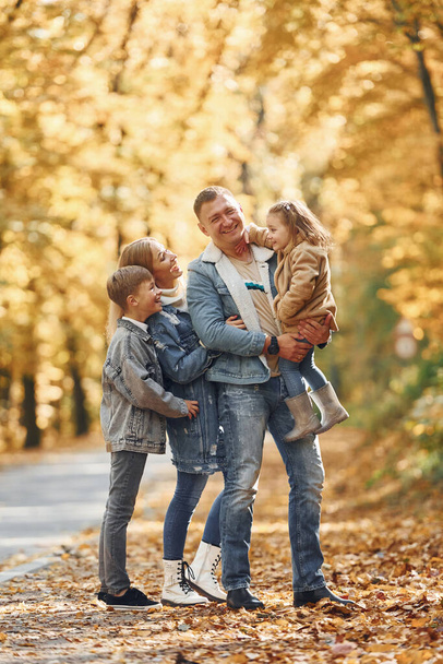 Near the road. Happy family is in the park at autumn time together. - Foto, Imagem