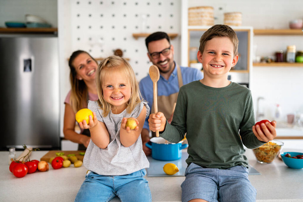 Happy young family preparing healthy food together in kitchen. People happiness cooking concept - Foto, Imagen