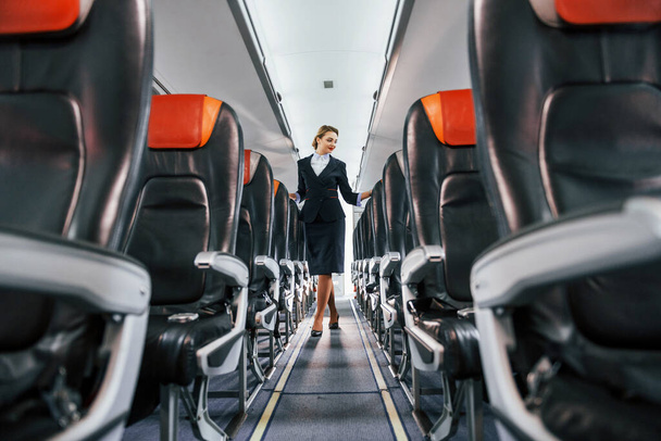 Empty seats. Young stewardess on the work in the passanger airplane. - Foto, Bild