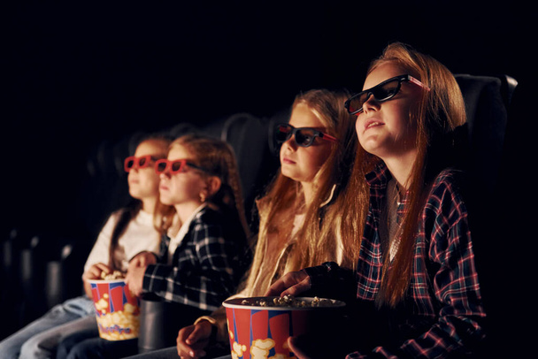 Facial expressions. Group of kids sitting in cinema and watching movie together. - Φωτογραφία, εικόνα