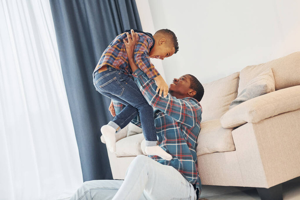 Active weekend time spending. African american father with his young son at home. - Fotó, kép