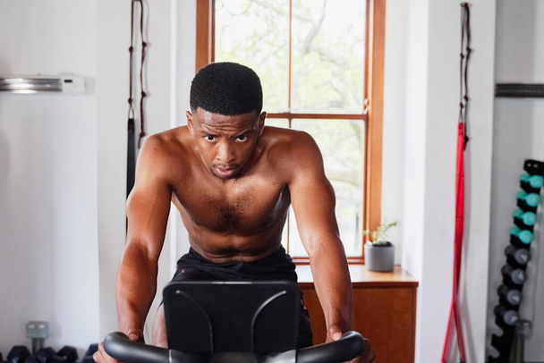 Shirtless determined young black man doing cardio workout on exercise bike at the gym - Φωτογραφία, εικόνα