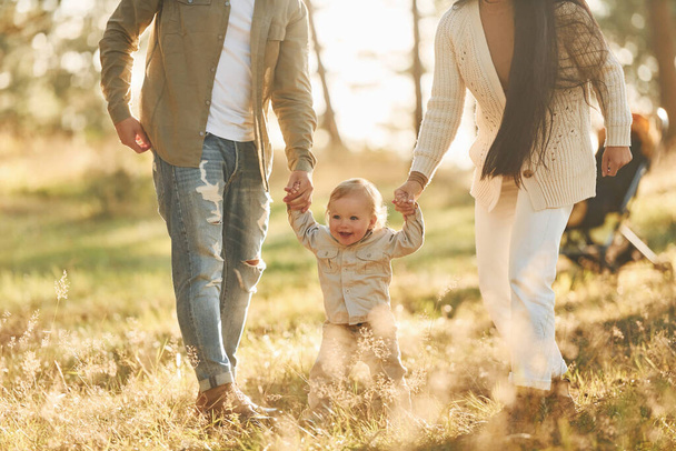 Having a walk. Happy family of father, mother and little daughter is in the forest. - Foto, Imagem