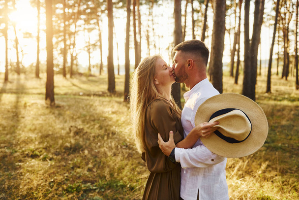 Embracing and kissing. Happy couple is outdoors in the forest at daytime. - Fotoğraf, Görsel