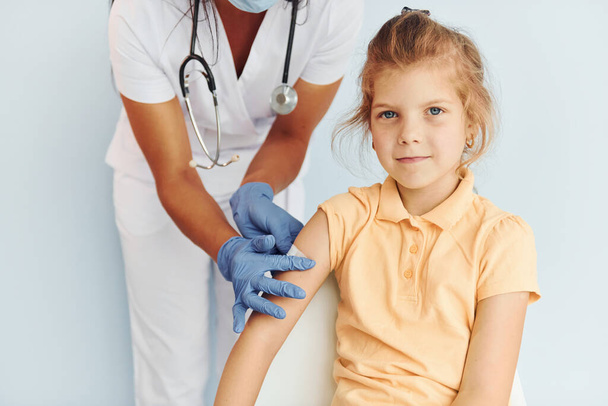 Cute little girl. Doctor in uniform making vaccination to the patient. - Fotoğraf, Görsel