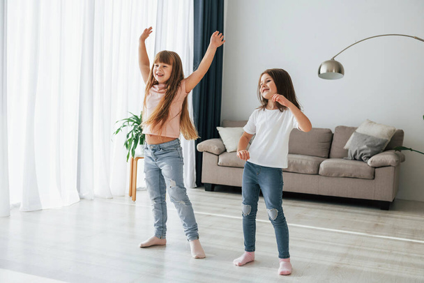 Dancing together. Kids having fun in the domestic room at daytime. - Fotó, kép