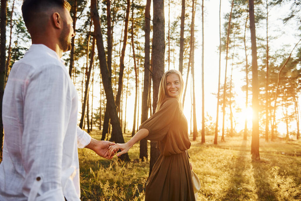 Follow me, concept. Happy couple is outdoors in the forest at daytime. - Photo, image