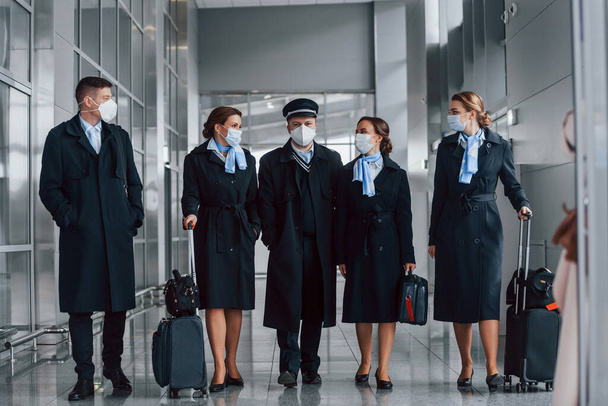Aircraft crew in work uniform is together outdoors in the airport. - Φωτογραφία, εικόνα