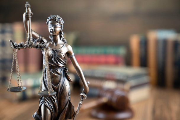 Jogi téma - bírói iroda. Themis szobor és jogi könyvek a bíró asztalán.  - Fotó, kép
