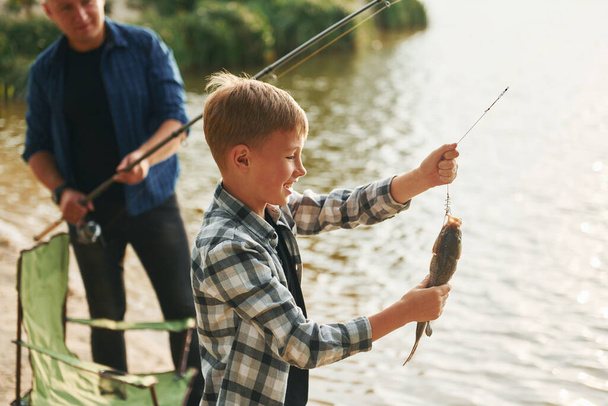 Showing the catch. Father and son on fishing together outdoors at summertime. - Foto, Imagem