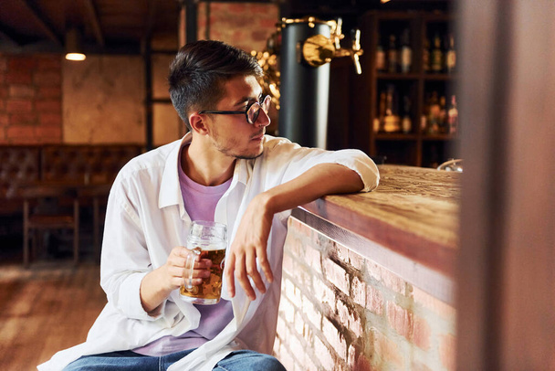 On the chair. Man in casual clothes sitting in the pub. - Photo, Image