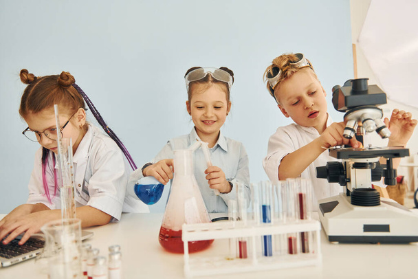 Test tubes with colorful liquid. Children in white coats plays a scientists in lab by using equipment. - Foto, afbeelding