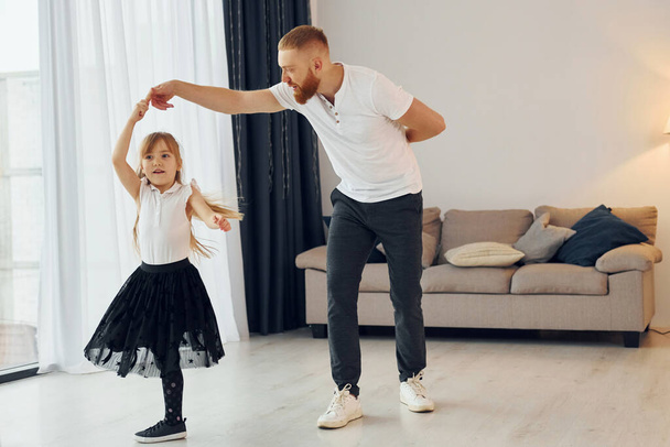Learning to dance. Father with his little daughter is at home together. - Фото, зображення