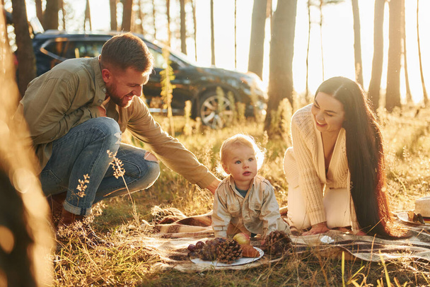Playful mood. Happy family of father, mother and little daughter is in the forest. - Foto, imagen