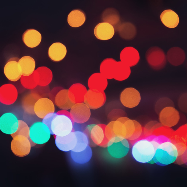 Colorful bokeh on a dark background. Defocused bokeh lignts. Abstract Christmas batskground. Abstract circular bokeh background of Christmaslight. - Photo, Image