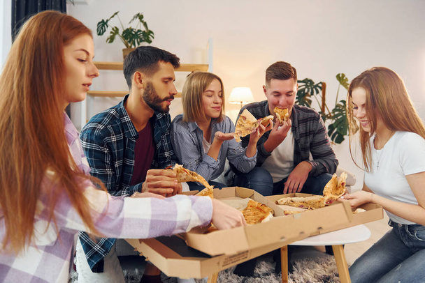 With delicious pizza. Group of friends have party indoors together. - Φωτογραφία, εικόνα