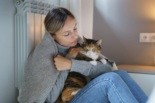 Young woman hugs domestic pet enjoying spending time with favourite cat. Animal makes owner happy and helps to walk through problems and bad thoughts. Female has motivation to make life better - Foto, immagini