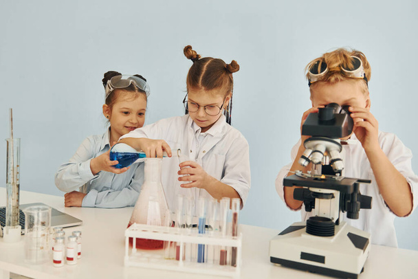 Test tubes with colorful liquid. Children in white coats plays a scientists in lab by using equipment. - Foto, Imagem