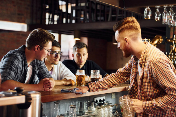 Cheerful young people in casual clothes sitting in the pub. - Foto, Imagem