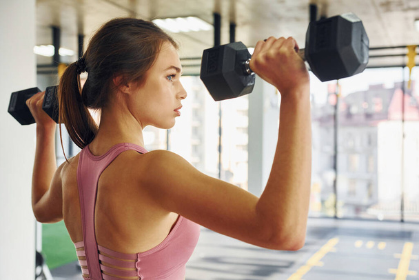 Young woman with slim body type is in the gym. - Фото, изображение