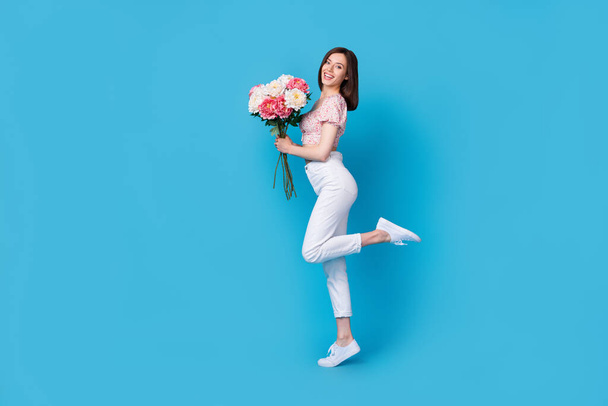 Photo of positive cheerful lady stylish clothes clothes hand hold boyfriend gift anniversary empty space isolated on blue color background. - 写真・画像