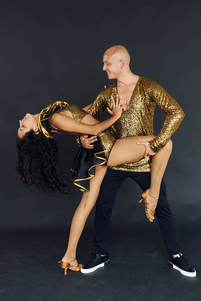 Professional dancers. Cheerful couple is together indoors. - Foto, afbeelding