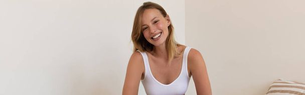 Positive blonde woman looking at camera at home, banner  - Foto, Imagen