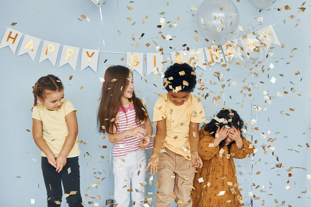 Balloons and confetti. Children on celebrating birthday party indoors have fun together. - Photo, image