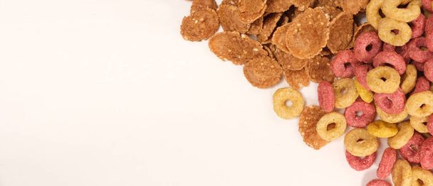 Miscellaneous quick breakfast cereals - wheat flakes and corn rings on a white background, space for text. - Fotó, kép