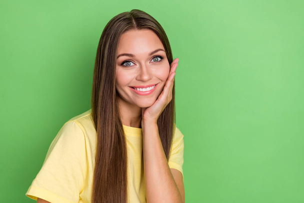 Photo of nice lovely adorable girl with straight hairdo dressed yellow t-shirt palm touch face isolated on green color background. - Zdjęcie, obraz