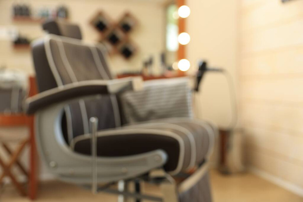 Blurred view of professional barber chair in hairdressing salon - Φωτογραφία, εικόνα