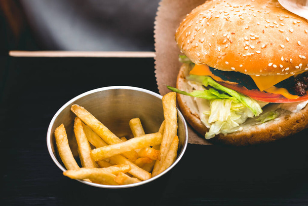 Délicieux burger frais avec frites sur la table en bois noir - Photo, image