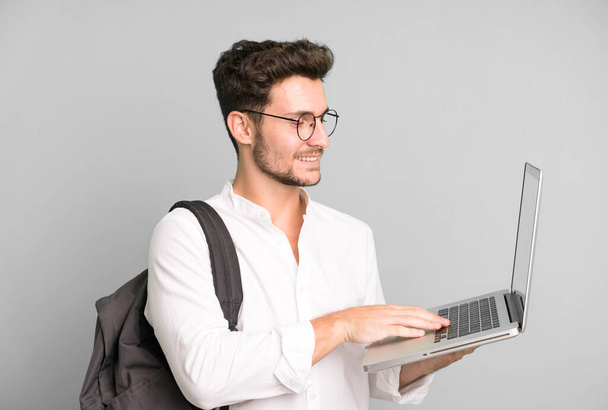 young handsome man isolated with a laptop. university student concept - Foto, Bild