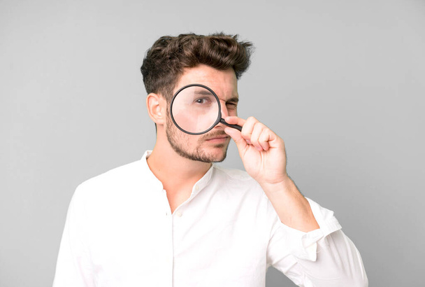 young handsome man with a magnifying glass. search or find concept - Фото, зображення