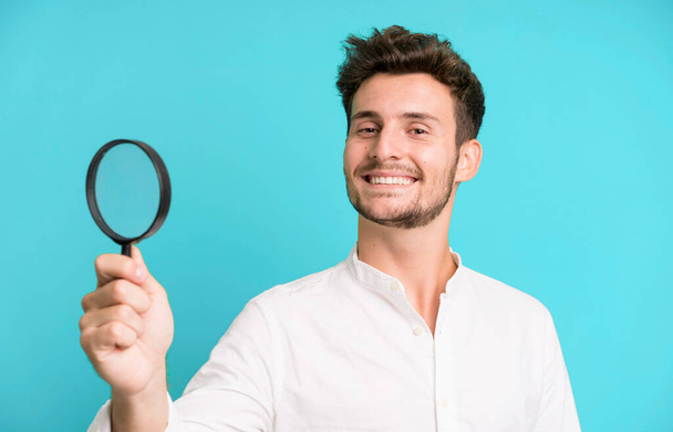 young handsome man with a magnifying glass. search or find concept - Foto, immagini