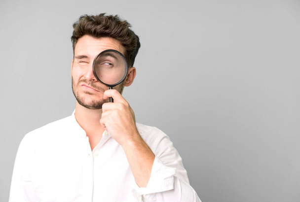 young handsome man with a magnifying glass. search or find concept - Фото, зображення