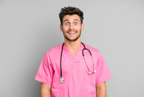 handsome teenager looking happy and pleasantly surprised. nurse concept - Foto, immagini