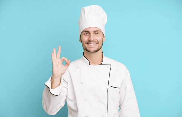 handsome teenager feeling happy, showing approval with okay gesture. chef concept - Fotó, kép