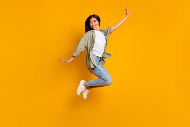Full body portrait of cheerful gorgeous lady have fun good mood jumping isolated on yellow color background. - Фото, изображение