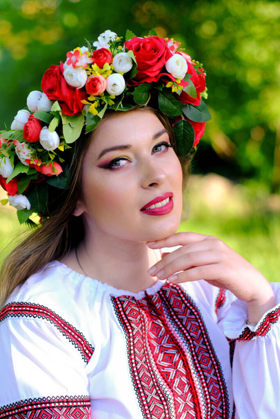 Крупным планом портрет красивой украинской девушки в традиционном платье и венок на голове. Вертикальное изображение. - Фото, изображение