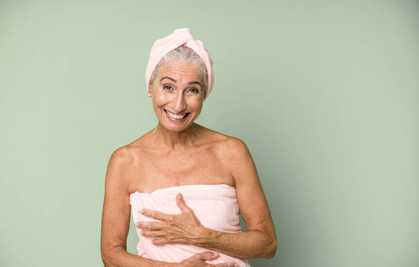 gray hair pretty woman laughing out loud at some hilarious joke. wearing bathrobe and towel. beauty concept - Foto, afbeelding