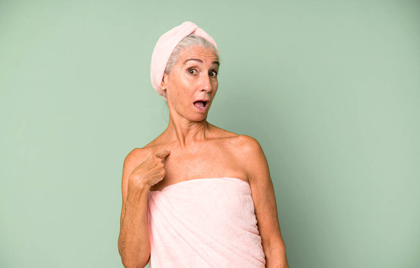 gray hair pretty woman looking shocked and surprised with mouth wide open, pointing to self. wearing bathrobe and towel. beauty concept - Φωτογραφία, εικόνα