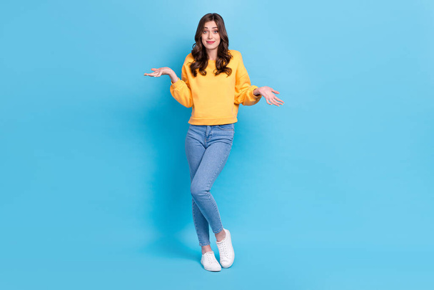 Full length photo of doubtful unsure girl dressed yellow pullover shrugging shoulders isolated blue color background. - Φωτογραφία, εικόνα