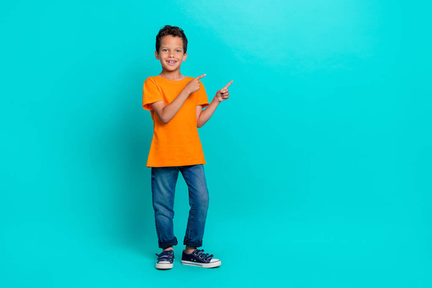 Full length photo of cheerful boy two arm direct demonstrate empty space proposition school supply shop isolated on cyan color background. - Fotoğraf, Görsel