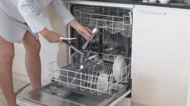 Μια γυναίκα γεμίζει το πλυντήριο πιάτων το πρωί στο σπίτι. - Πλάνα, βίντεο