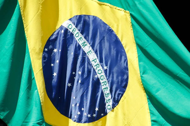 Brasilianische Flagge in Unterstützung und Wind - Nationaler Pavillon - Brasilianisches Heimatsymbol - Brasilianische Flagge flattert von einem Fahnenmast - Foto, Bild
