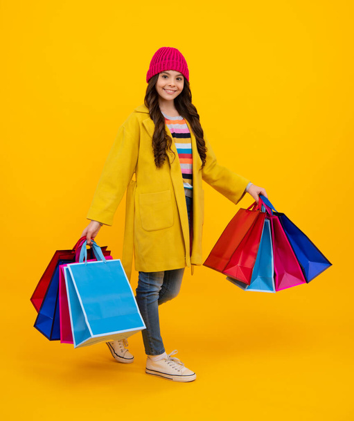 Stylish teen girl with shopping sale bags. Kid holding purchases. Fashion style of trendy child. Happy teenager, positive and smiling emotions of teen girl - Φωτογραφία, εικόνα