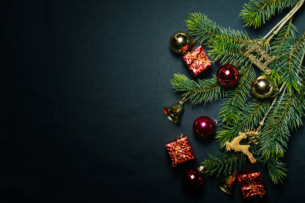 Концепция Рождества. Вид сверху рождественской подарочной коробки разноцветные шарики с ветвями и колокольчиком на черном фоне. - Фото, изображение