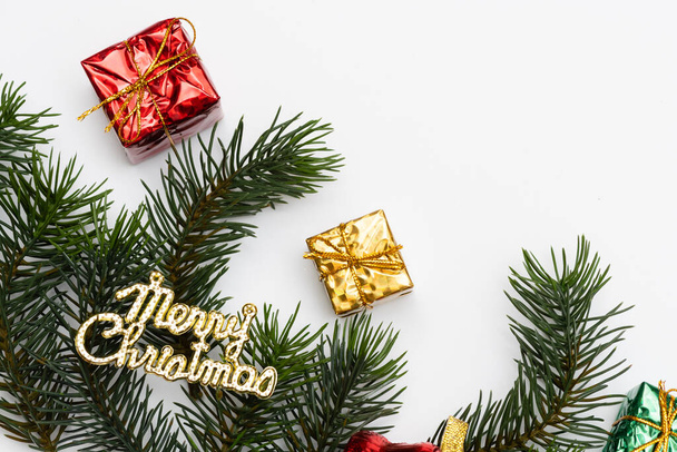 Fröhliche Weihnachtskarte aus Tannenzweigen, Geschenkschachteln, roter Dekoration, Funkeln und Konfetti auf weißem Hintergrund. Weihnachten und Neujahr, Bokeh, Licht. Flache Lage, Draufsicht - Foto, Bild